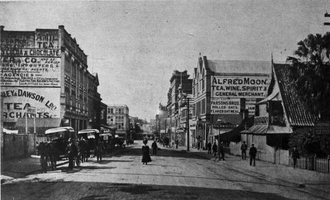View of a historic Adelaide St, with cars and people walking