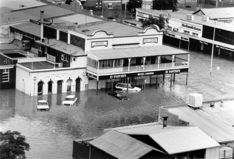 Aerial view of a flooded township, with the top story of a pub visible