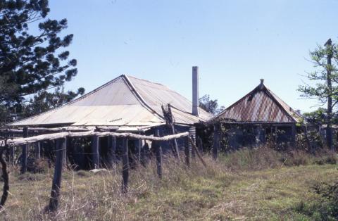 Run down heritage homestead with wooden fence in foreground