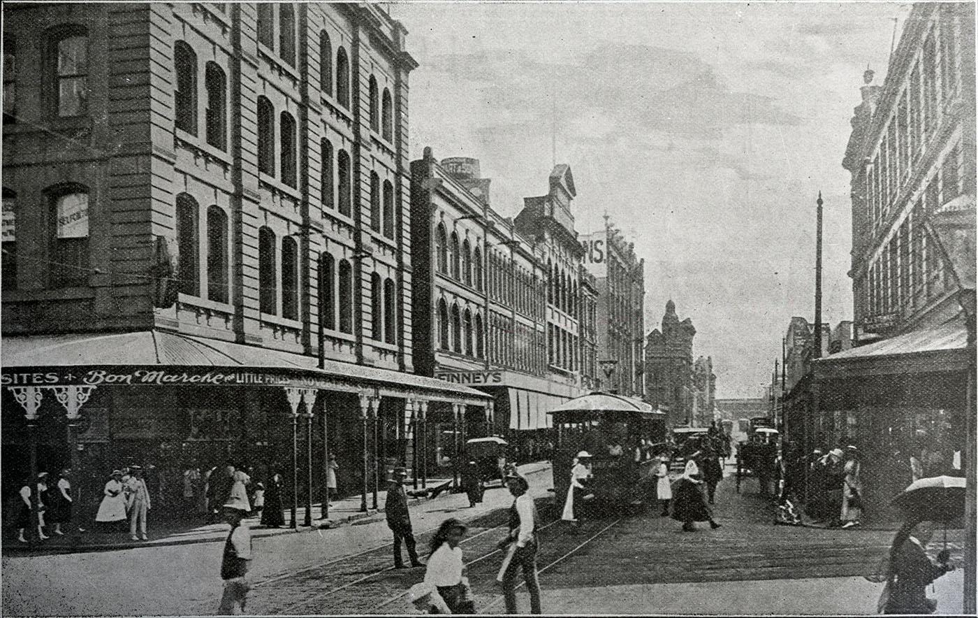 View of Adelaide Street showing people and cars down the main street
