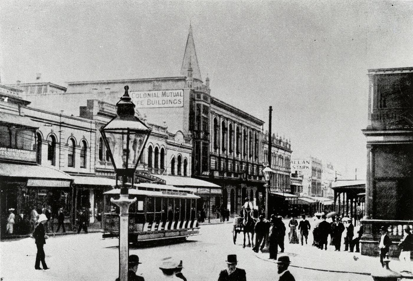 The corner of Queen and Goerge Streets showing many people out walking the streets in period dress