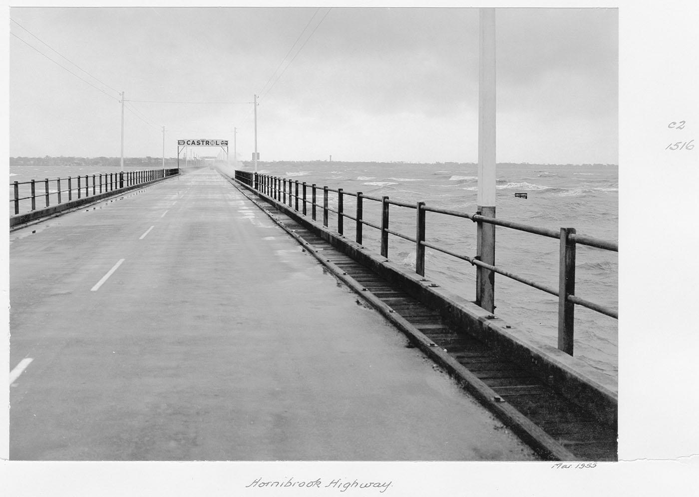 View from along the old Hornibrook Bridge towards Clontarf/Woody Point with Castrol banner sign in the distance.