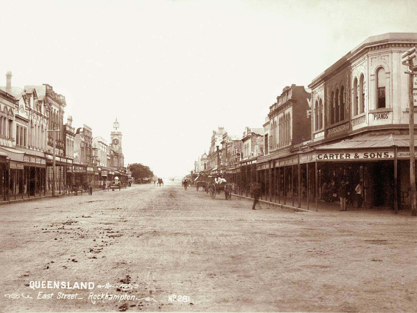 View of East Street, Rockhampton showing carts, horses and buildings.