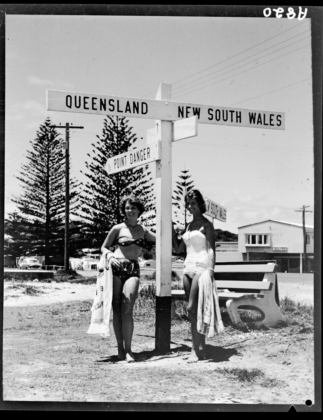Beach girls at Queensland and New South Wales border post, Coolangatta