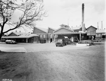 Exterior of a 1950s dairy viewing the car park and exterior of the mil factory