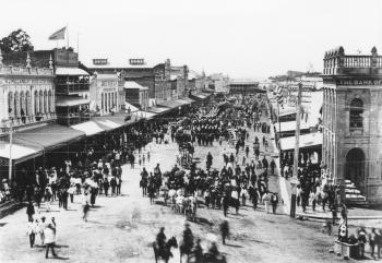 Crowded street scene showing hundreds of people gathered in the streets of Townsville for a procession